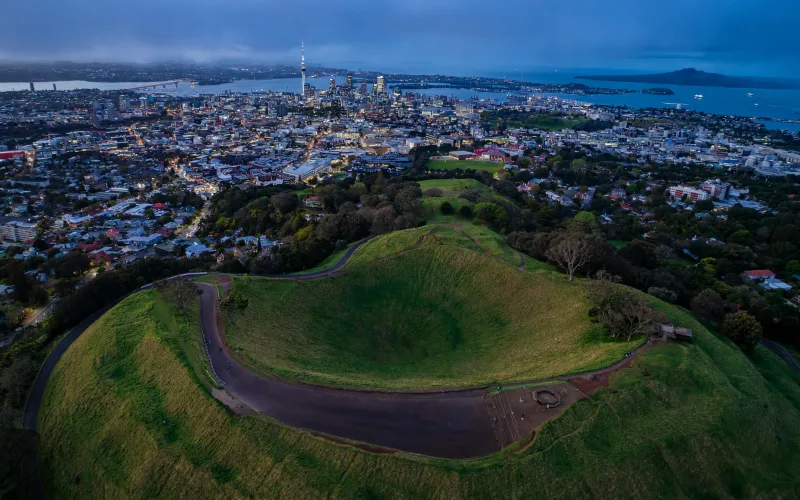Auckland skyline from Mount Eden over the volcanic crater and harbour at dusk