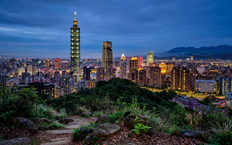 Taipei skyline with Taipei 101 over city and hills at blue hour