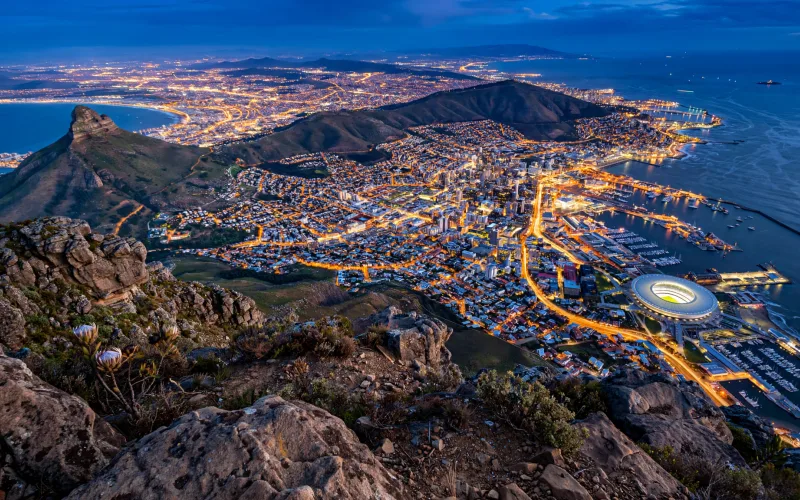 Cape Town seen from Table Mountain above the illuminated city and harbour at dusk